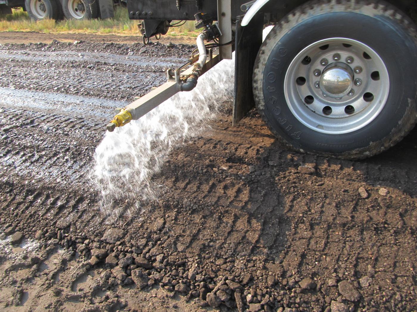 Spray bar applying liquid to a prepared road surface